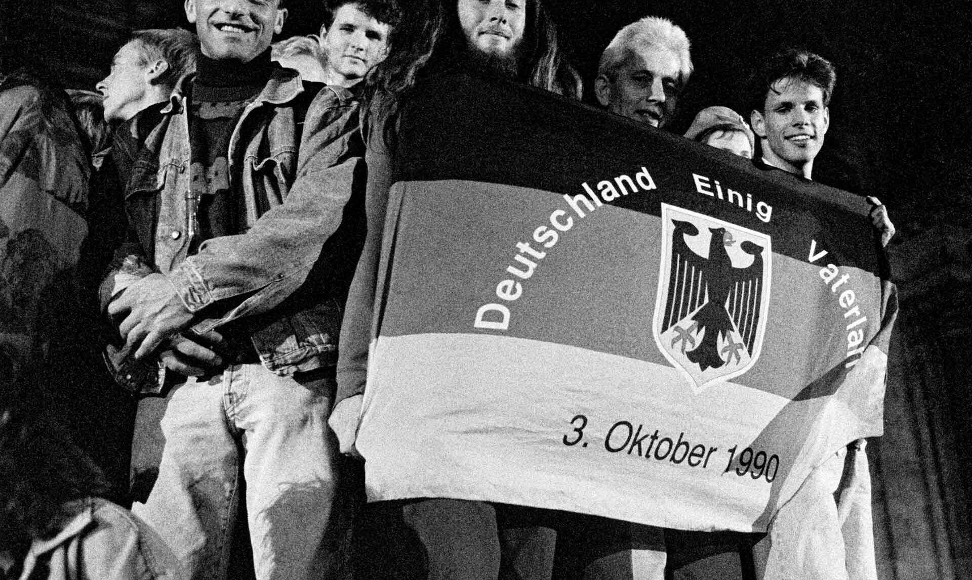 Menschen mit Flagge zur Deutschen Einheit.
